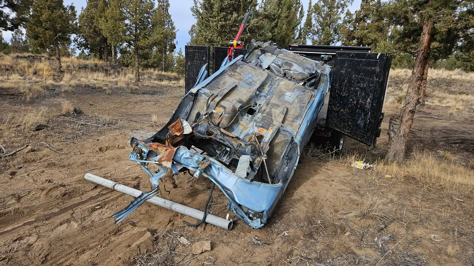 An old camper torn down in a dirt lot, ready to load
