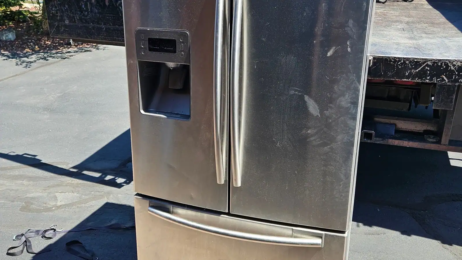 A stainless steel French door refrigerator out on a driveway