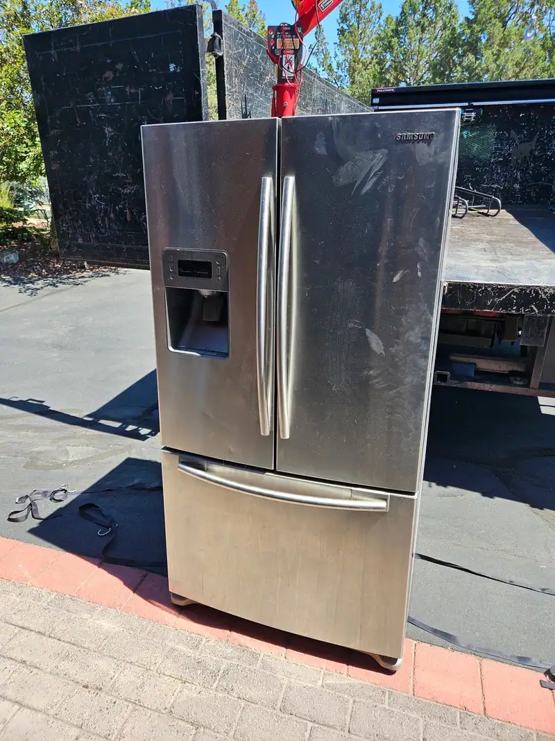 A stainless steel French door refrigerator out on a driveway
