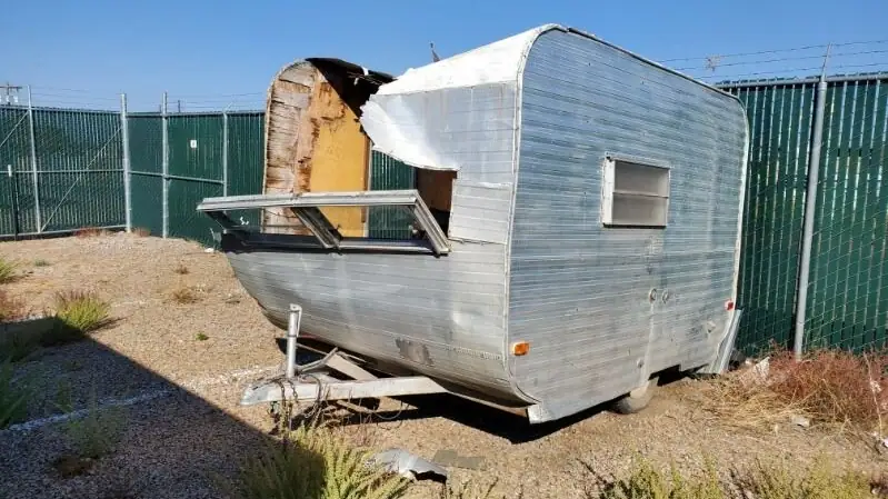 A vintage camper with its shell torn open, ready to be hauled away